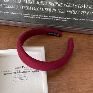 Detailed macro view of the handmade woven burgundy headband with vintage fabric texture