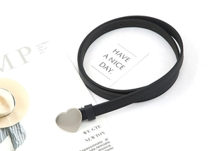 Detailed view of a black skinny leather belt featuring a silver heart-shaped metal buckle