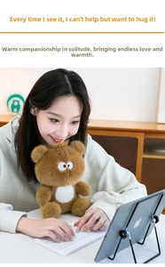 Close-up of a fluffy brown teddy bear plush toy with soft long fur in a cozy office setting