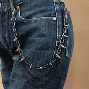 Close-up of gun black multi-layered punk wallet chain with decorative metal spikes on denim