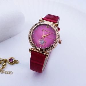 Detail of rose gold watch with sparkling rhinestones, pink gradient dial and red leather strap