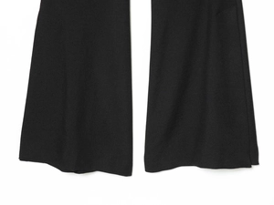 Detail of straight leg hem on black woven trousers showing fine twill fabric texture