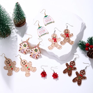 Detail of Christmas earrings featuring gingerbread man and sleigh all day sweater design