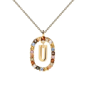 Close-up of golden oval pendant with letter U surrounded by colorful zircon gemstones