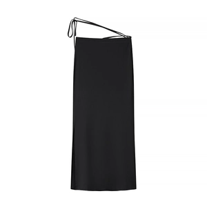 Detail view of a black midi skirt with tie-waist straps and a side slit design