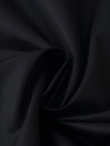 Vista macro del tessuto intrecciato nero ad alta densità con drappeggi morbidi e dettagli