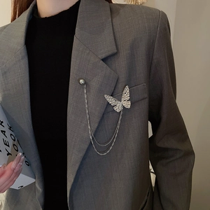 Detailed view of silver butterfly brooch with rhinestones and multi-layer pearl chains