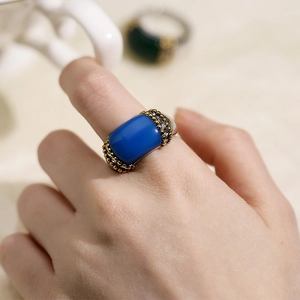 Macro detail of a rose gold steel ring featuring a royal blue cat-eye stone setting