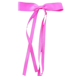 Elegant pink ribbon bow hair clip with long streamers on a white background
