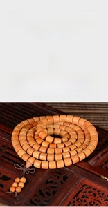 Detailed view of polished sandalwood barrel beads on an ornate wooden display stand