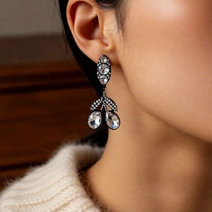 Gros plan de boucles d'oreilles pendantes vintage en forme de feuille sur l'oreille
