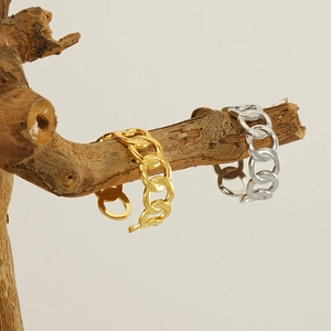 Detailed shot of gold and silver chain rings hanging on natural wooden branches