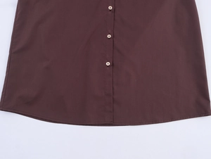 Close-up of chestnut brown shirt featuring button-down details and curved hem stitching