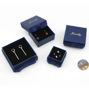 Detailed top view of dark blue jewelry gift boxes with matching ribbon bows and gold logo