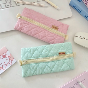 Close-up of quilted pastel pencil cases with metal zippers and woven Sozakka labels