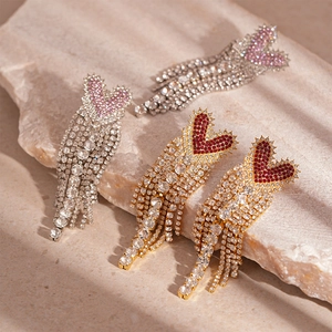 Luxury heart tassel earrings with rhinestones in gold and silver finish on stone base