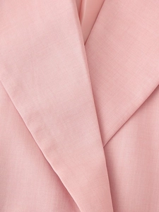 Dettaglio del risvolto del blazer rosa che mostra la trama fine del tessuto twill