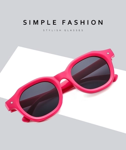 Detail of square pink sunglasses with dark grey lenses and silver metal rivet accents