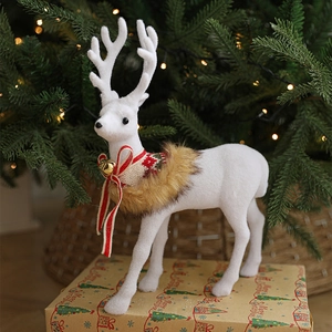 White Christmas elk statue with red bow and gold bells on festive holiday gift box