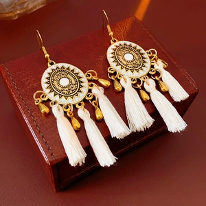 Bohemian rhombus enamel sun earrings with white tassels on a vintage leather box