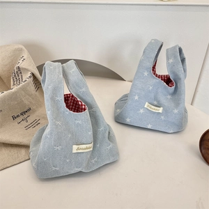 Detail of denim bucket bags with star patterns and red checkered lining interior