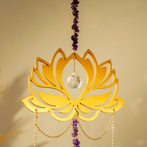Macro shot of golden lotus pendant with amethyst gravel and a clear crystal sphere