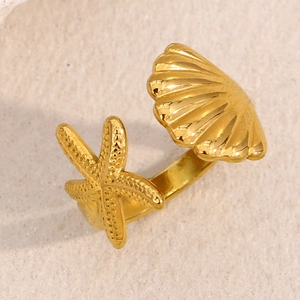 Detailed macro view of 18K gold starfish and scallop open ring with textured details