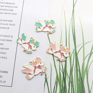 Detailed view of four colorful unicorn charms with gold plating and enamel finish