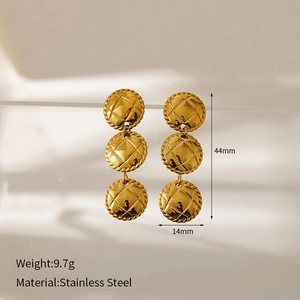 Macro detail of gold stainless steel earrings featuring three quilted round charms