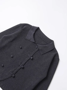 Close-up of dark grey knit top showing Chinese frog button detail and polo collar