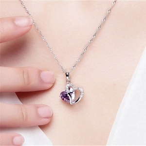 Close-up of S925 sterling silver heart pendant with purple gemstone on a female neck