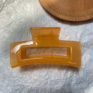 Detail of a large rectangular amber hair claw clip with a strong metal spring
