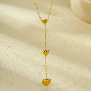 18K gold plated stainless steel necklace featuring three layered heart charms on marble