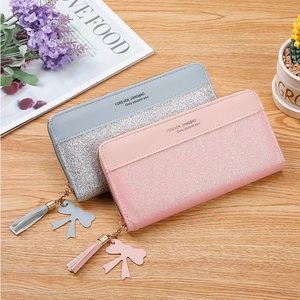 Detail of color-blocked long zip wallets with elegant tassels and glittery silver panels