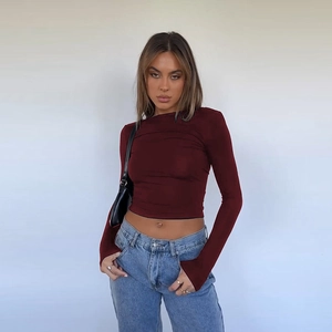 Detail of slim fit dark red long sleeve crop top with round neck and ribbed texture