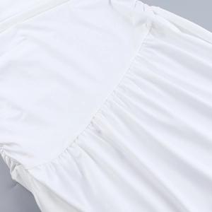 Détail rapproché montrant le tissu plissé et les fronces d'une robe d'été blanche