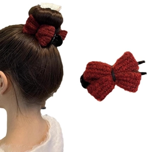 Red knitted bow hair claw clip for bun hairstyles on a clean white background