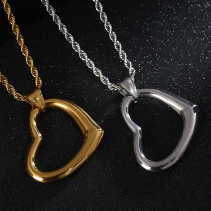 Close-up of gold and silver hollow heart pendants on black sparkling background