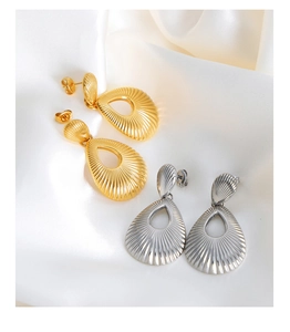 Detailed close-up of hollow teardrop earrings with radial ripple texture on silk