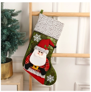 Détail de chaussette de Noël verte avec Père Noël 3D et motifs flocons sur bois