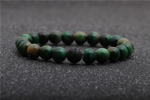 Macro view of 8mm green tiger eye and black lava stone beads on elastic bracelet