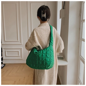 Close-up of green quilted hobo bag featuring soft padded shoulder strap and check pattern