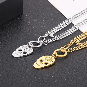 Close-up of gold and silver skull pendants on Cuban chains with hollow details