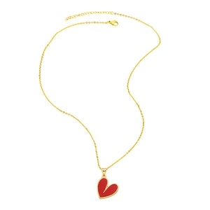 Close-up of golden irregular heart pendant with red enamel and beaded edge detail