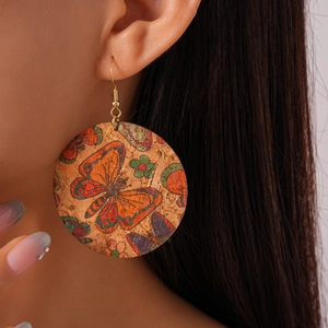 Detailed close-up of Bohemian cork earrings with colorful butterfly and floral patterns