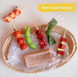 Close-up of realistic resin food hair clips including meat and edamame in a basket