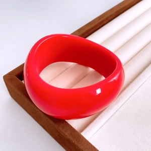 Detaillierte Ansicht des roten Acryl-Armreifs mit Hochglanz-Finish in weißer Schmuckbox