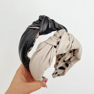 Detail of knotted leather headbands in black and beige with polka dot inner lining texture