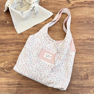 Detail of floral tote bag showing pink plaid pocket with bow and zakka label