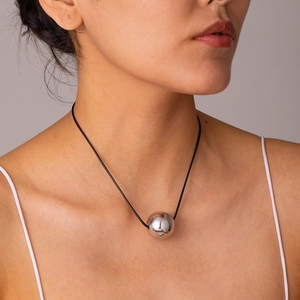 Close-up of a silver stainless steel ball pendant on a black adjustable wax cord necklace